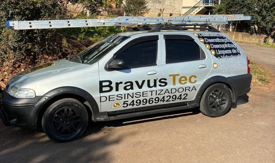 Carro de serviço da BravusTec adesivado com a marca, o telefone 54996942942 e a lista de serviços, com escada de alumínio no rack de teto